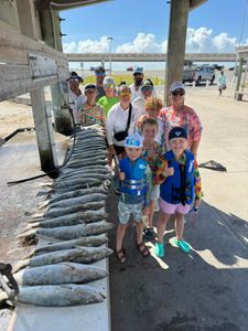 Group of 12 people fishing on shore in TX