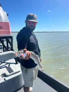 Angler holding caught fish on boat in Rockport TX waters