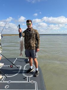 Angler holding caught redfish on fishing boat in Rockport TX waters