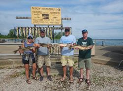 A group of 4 people fishing on a boat in Conneaut