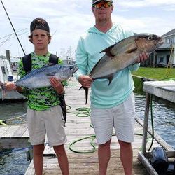 Two Greater Amberjack fish, 19 inches long, caught by two people in Atlantic Beach