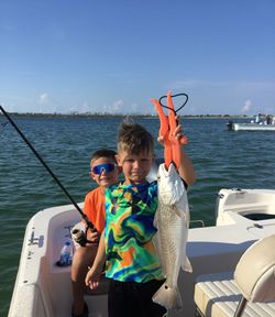 A pair of anglers holding a redfish caught in Florida while fishing.
