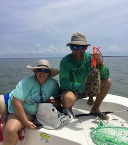 Anglers catching a southern flounder fish in Florida