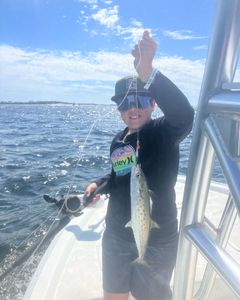 A Spanish mackerel fish being held by two people in Panama City Beach