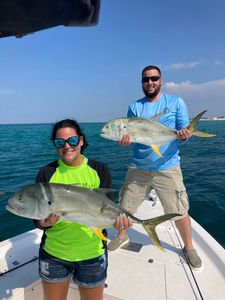 Two giant trevally and African Pompano fish in a fishing scene in FL
