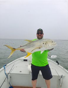 A fisherman holding a large Crevalle Jack fish in Port O'Connor