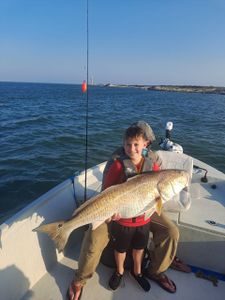 A single fisherman holding a large 37-inch catch in Port O'Connor