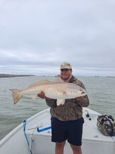A lone fisherman reeling in a catch in Port O'Connor