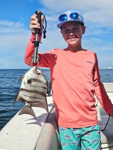 Angler holding a small fish in Orange Beach