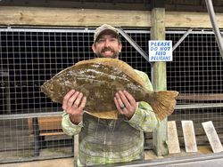 A fisherman holds a large 31-inch summer flounder in Matagorda