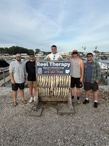 Successful fishing charter display with multiple caught fish hanging on wooden rack at Oregon OH marina