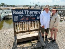 Successful walleye fishing trip display at Oregon OH marina with multiple fish on cleaning board