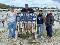 Successful fishing charter in Oregon OH displaying large catch of walleye on wooden rack at marina