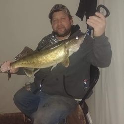 A photo of a fisherman holding a 18-inch walleye in Ontario, Canada.