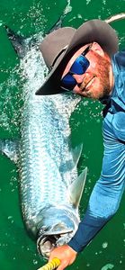 Large tarpon being held in green water after being caught while fishing in Destin FL