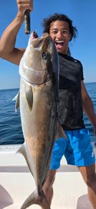 A fisherman holding a greater amberjack fish in FL