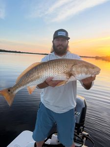 A fisherman holding a redfish in FL