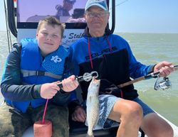 A fisherman holding a spotted weakfish catch in Corpus Christi