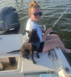 Fishing boat with dog companion on water in Manns Harbor NC