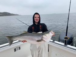 A fisherman catching a striped bass in Neptune