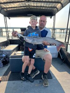 Two people fishing for a blue catfish in Port Clinton