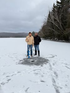 Two people standing on snowy ground in winter outdoor setting at Owls Head NY
