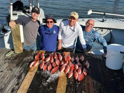 Four people enjoying a fishing trip in Pensacola