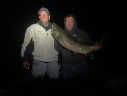 Two people fishing in Pulaski with a 27-inch fish