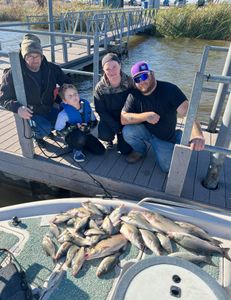 Four people fishing with rods in a scenic location