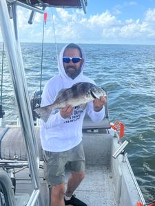 A fisherman holding a black drum fish in Mannford