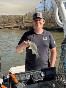 Angler holding freshly caught fish on boat in Mannford OK
