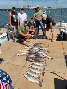 Fishing group displays catch of striped bass and catfish on dock in Mannford OK