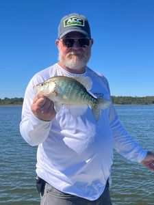 A person fishing for a white crappie in Mannford