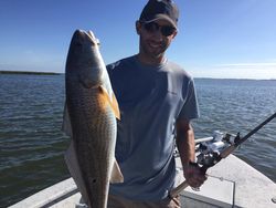 A person holding a large redfish caught while fishing in Port Aransas