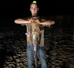 A lone angler fishing with a rod in an orange location