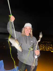 Orange nighttime fishing success with lights dancing on water!