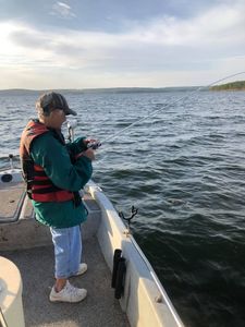 Two people fishing near a body of water in OK