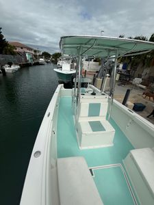 Fishing boat with turquoise interior and T-top canopy docked in marina canal in Florida