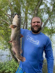 A photo of a fisherman holding a huge blue catfish at Grand Saline