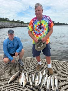 Successful fishing trip in Gulf Shores AL with speckled trout and redfish catch displayed on boat deck