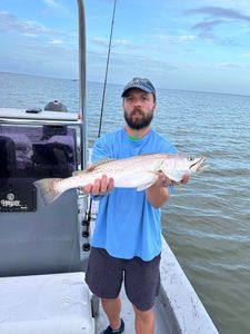 Angler holding caught speckled trout on fishing boat in Corpus Christi TX waters
