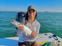 An angler holding a small fish in the Bay Pines location.