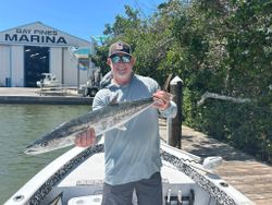 A fisherman holds a 27-inch king mackerel in FL.