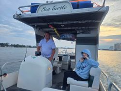 Tour boat named Sea Turtle on water during sunset in Fort Walton Beach FL