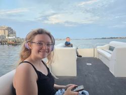 Tour boat on calm water near Fort Walton Beach FL with coastal buildings and cloudy sky