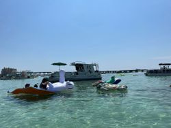 Tour boats and inflatable floats on clear water in Fort Walton Beach FL