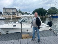 California flounder catch displayed on dock at Mastic Beach NY marina with fishing boat