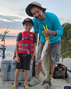 Angler holding a large blue catfish caught in Mocksville