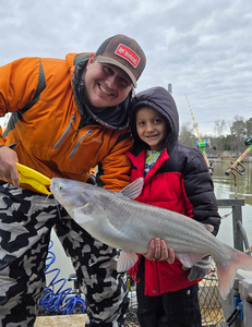 "The thrill of the catch: A proud angler showcases their prize fish in a tranquil lakeside setting."