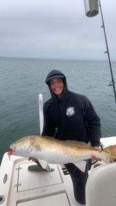 Angler holding a large redfish caught while fishing in NC